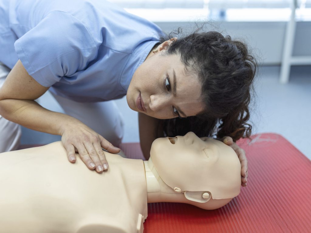 CPR class with instructors talking and demonstrating firt aid, compressions ans reanimation procedure. Cpr dummy CPR class with instructors talking and demonstrating firt aid, compressions ans reanimation procedure. Cpr dummy
